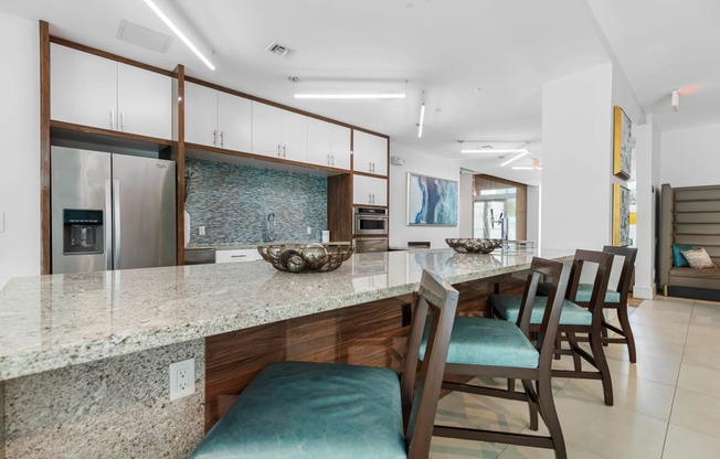 a kitchen with a long counter and a bar with chairs