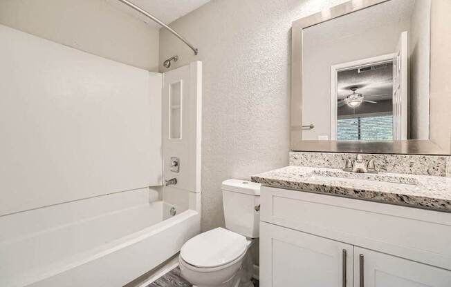 A white bathroom with a toilet, sink, and bathtub.