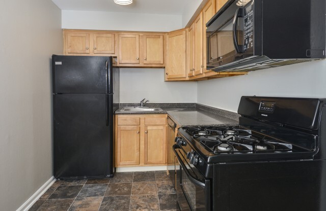 Stunning The Wellington kitchen with fantastic wooden cabinets and black appliances in Hatboro, PA