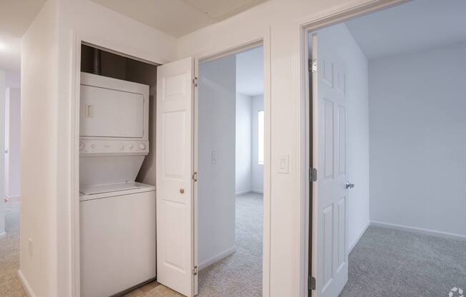 A white refrigerator is in a kitchen with a white door at Cornerstone at Gale Ranch Apartments, California, 94582