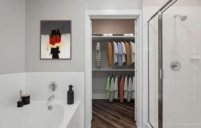 A bathroom with a white tub and a white door leading to a closet.