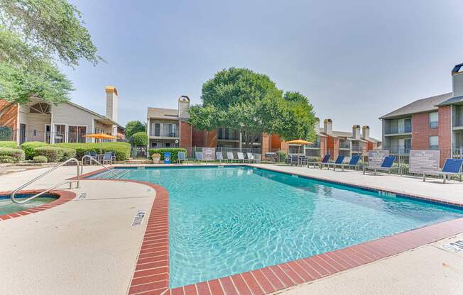 A large swimming pool surrounded by a red brick border at Copper Hill Apartments, Bedford, TX