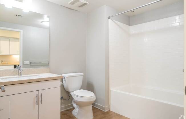 A white bathroom with a toilet, sink, and bathtub.