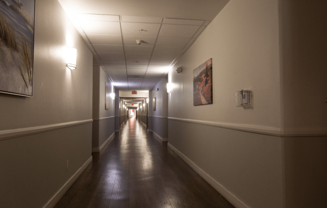 A long hallway with lights on the ceiling and walls.