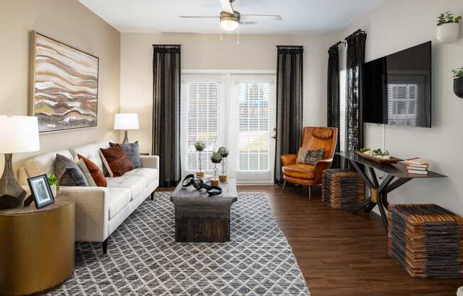 Furnished living room with a sofa, two nightstands, coffee table and wood-designed flooring at The Alexandria in Madison, AL