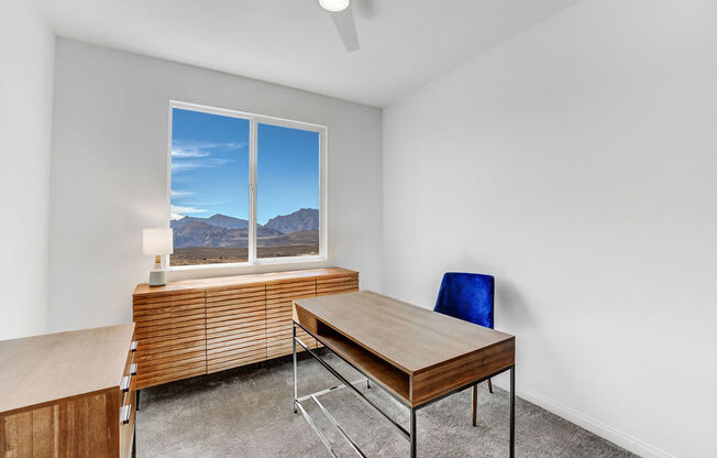 a office with a desk and a window with mountains