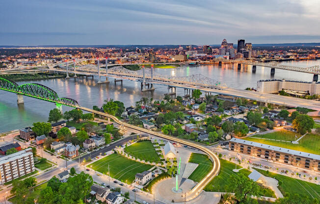 A cityscape with a river and a bridge in the background.