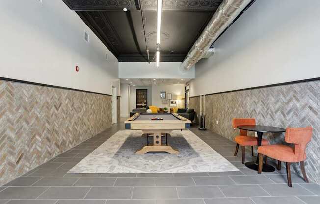 A long hallway with a table and chairs at the end.