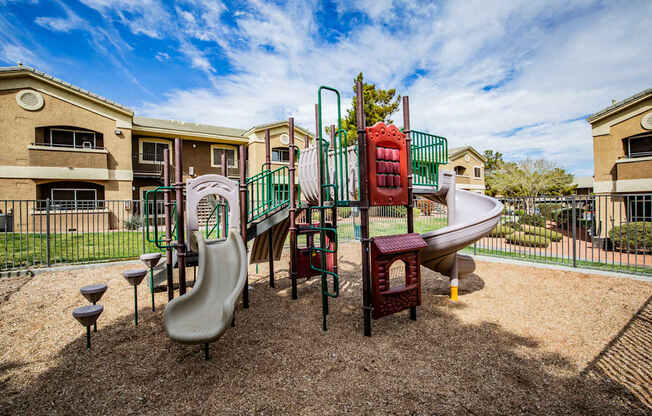 A playground with a slide, swings, and a seesaw.
