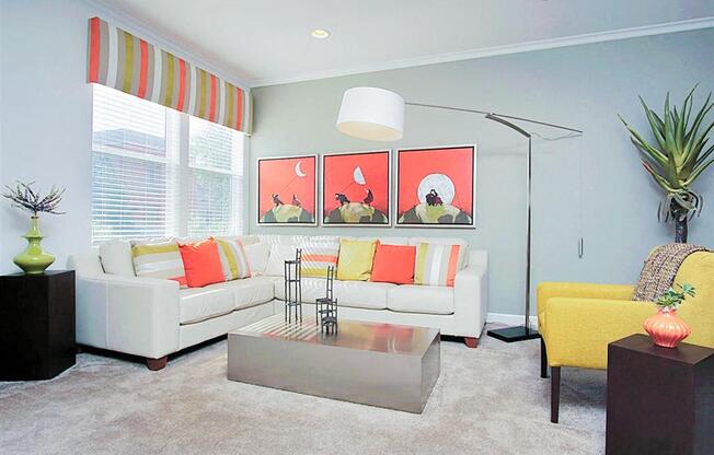 A living room with a white couch, a yellow chair, and a coffee table.