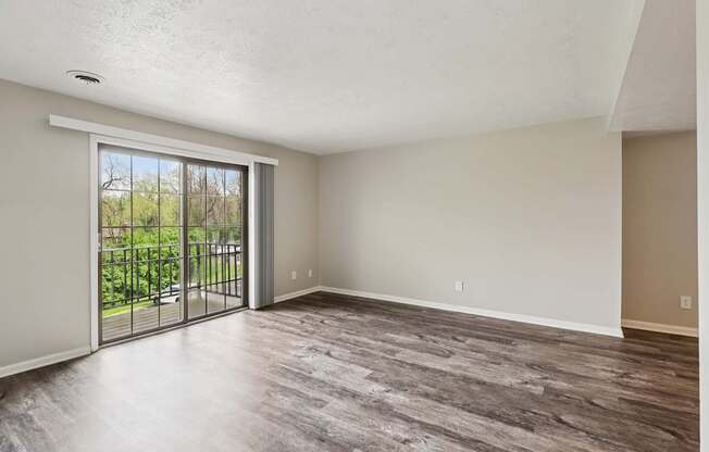A room with a sliding glass door leading to a balcony.