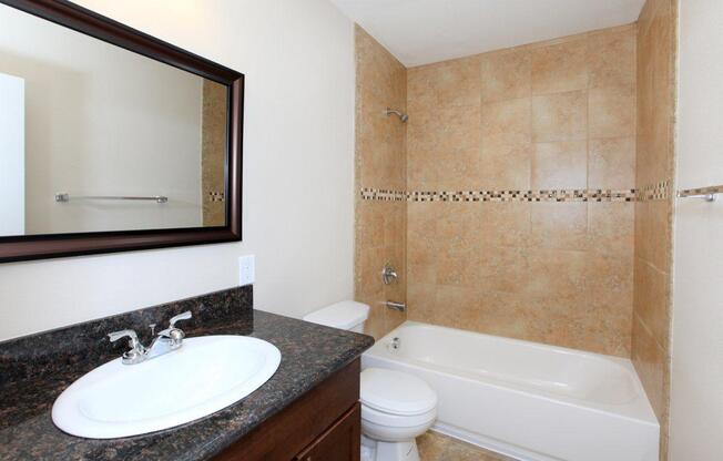a white sink sitting under a mirror