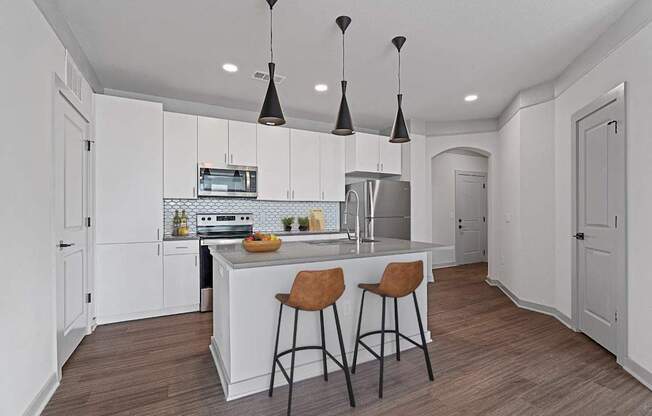 A kitchen with a white island and bar stools.