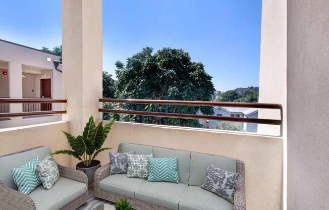 a terrace with two couches and a potted plant