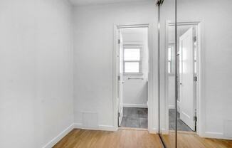 a bedroom with white walls and a mirrored closet