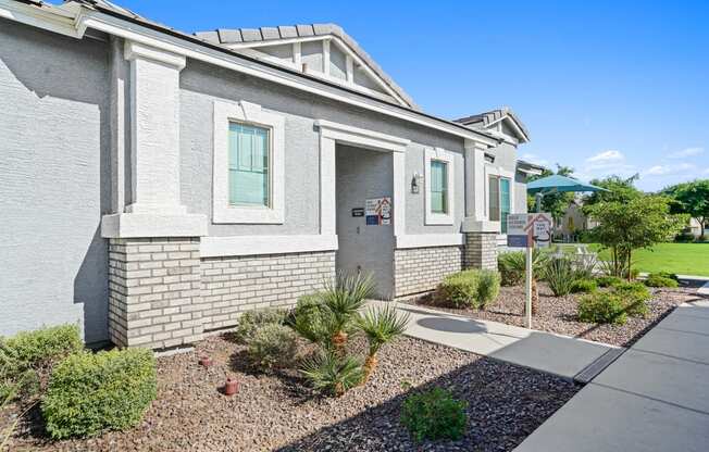 a white brick house with a sidewalk in front of it