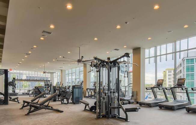 A gym with a variety of equipment including treadmills, weights, and exercise machines.