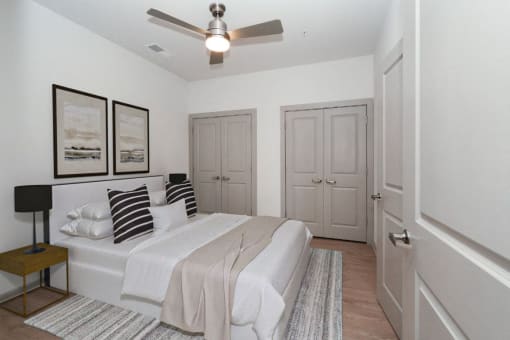 a white bedroom with a bed and a ceiling fan at The Waterford At Rocketts Landing Apartments, PRG Real Estate, Richmond, Virginia