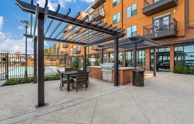 A patio with a table and chairs under a pergola.
