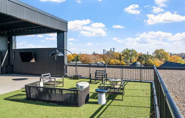 a patio with tables and chairs on a roof with a view of the city