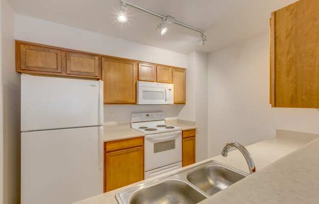 kitchen with double sink, oven, microwave and refrigerator