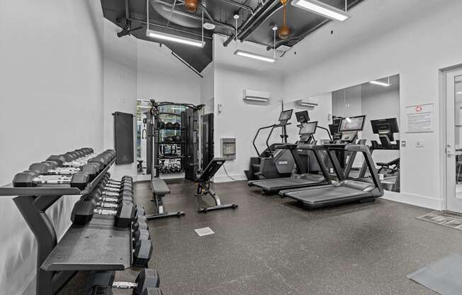 A gym with treadmills, exercise bikes, and other equipment.