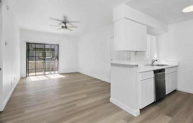 A white kitchen with a fan on the ceiling.