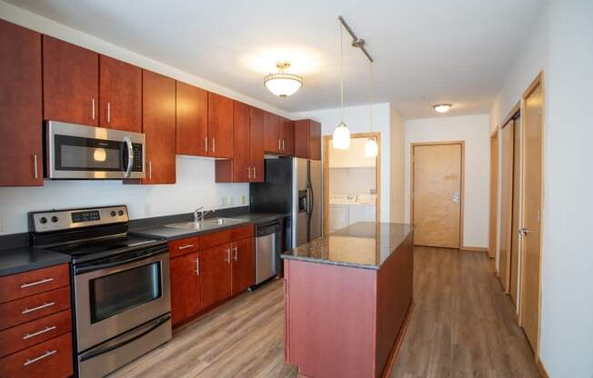 A kitchen with wooden cabinets and a black countertop.