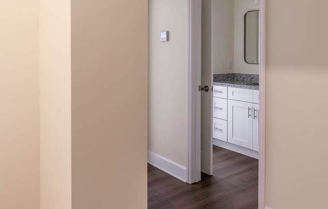 a view of a hallway with a door to a bathroom and a sink