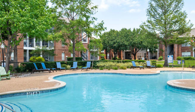 a swimming pool in front of an apartment building