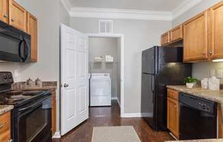 a kitchen with black appliances and wood cabinetry