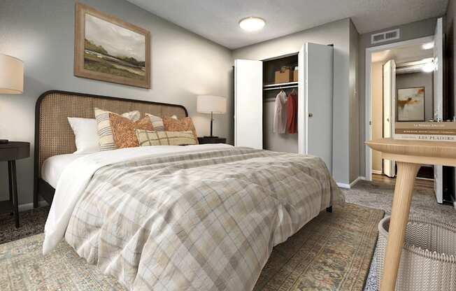 A bedroom with a bed, a desk, and a chair.
