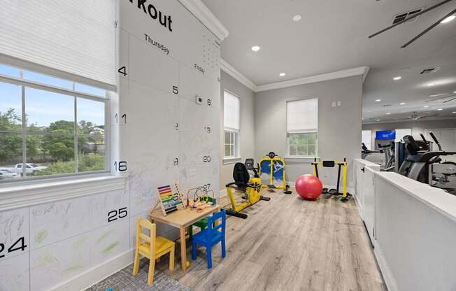 A calendar on the wall of a gym room with a red ball and exercise equipment.
