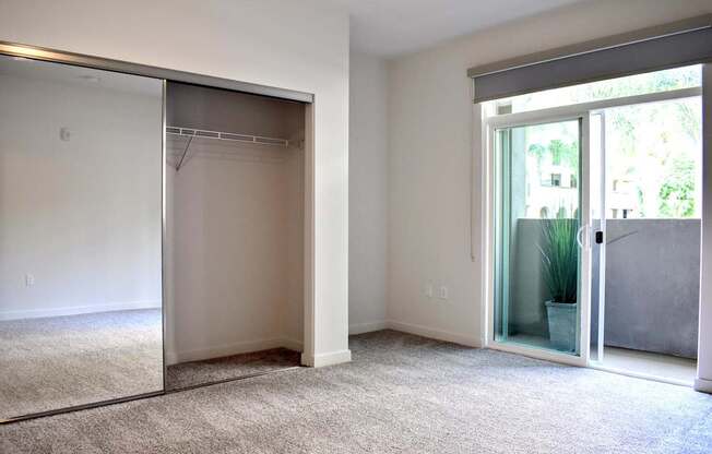 A room with a carpeted floor and a sliding glass door.