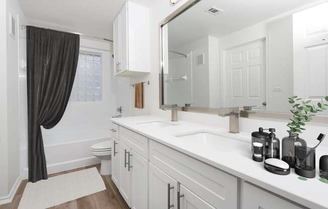 a bathroom with white cabinets and a sink and a toilet