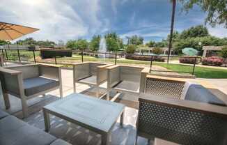 A patio area with tables and chairs and a fountain