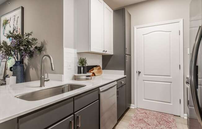 an empty kitchen with a sink and a door to a refrigerator