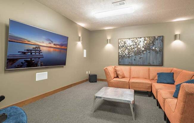 Theater room with large TV and couches at Villas of Omaha townhome apartments in northwest Omaha NE 68116