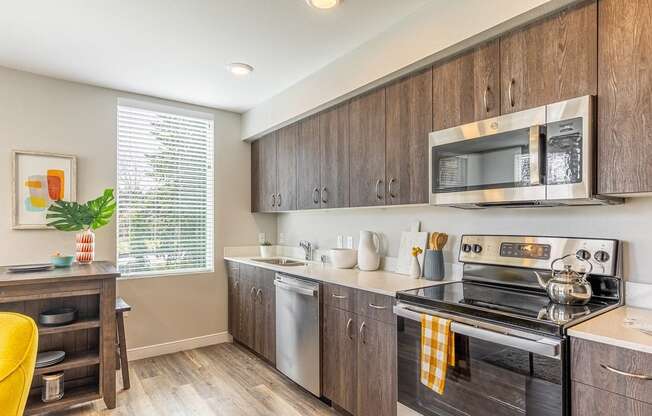 134th street lofts kitchen with wooden cabinets. stainless steel  stove, microwave and dishwasher