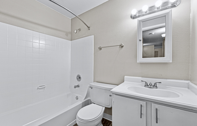 Sleek modern bathroom with a pristine bathtub, stylish vanity, and bright lighting.