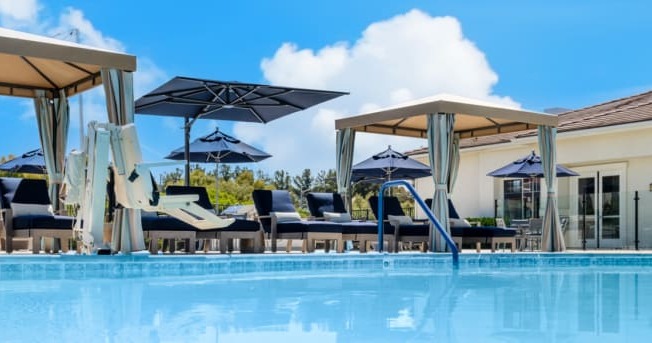 a swimming pool with chairs and umbrellas