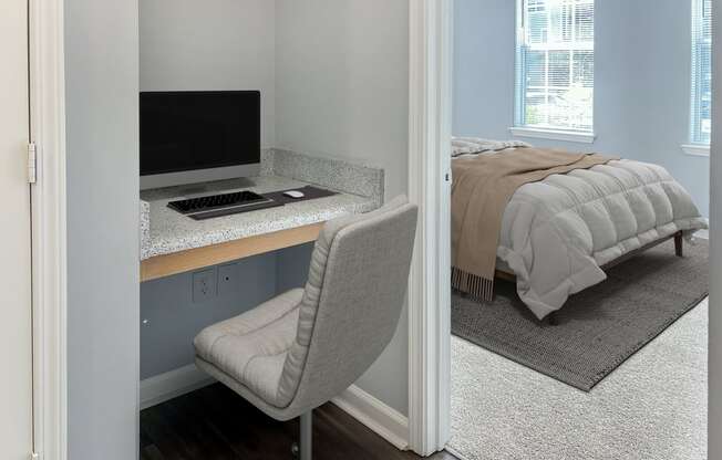 a bedroom with a bed and a desk with a computer