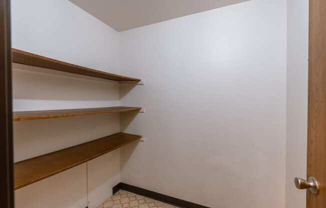 A small room with shelves and a door. Fargo, ND Long Island Apartments.