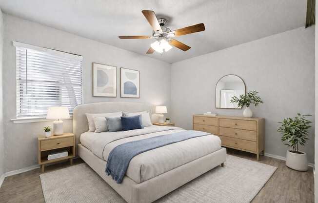 A bedroom with a bed, nightstands, and a plant.