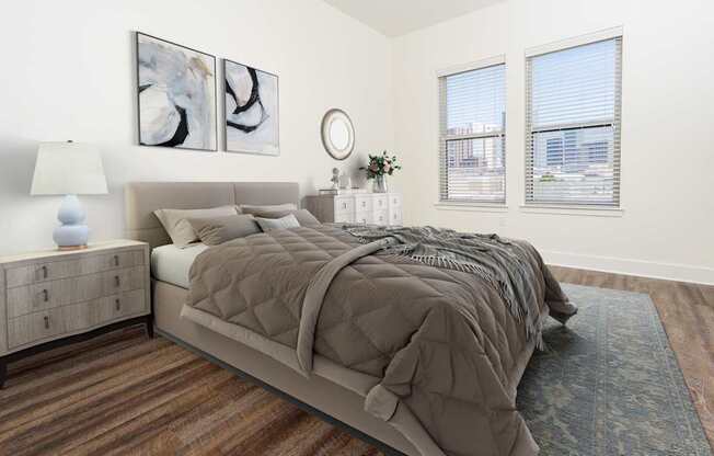 A bedroom with a large bed, a nightstand with a lamp, and two framed pictures on the wall.