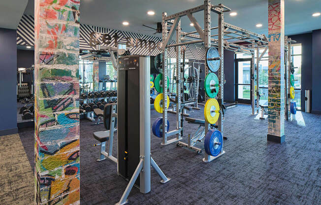 a gym with weights and cardio equipment in a building