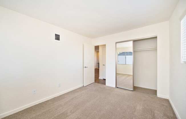 a living room with carpet and a sliding glass door to a bedroom