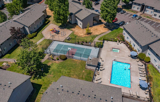 an aerial view of a house with a pool and tennis court