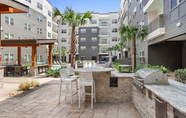 A patio with a table and chairs is surrounded by apartment buildings.