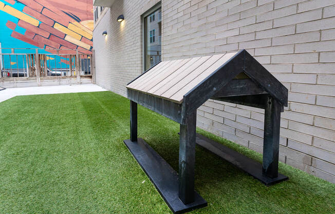 a bench in the yard of a building with artificial grass